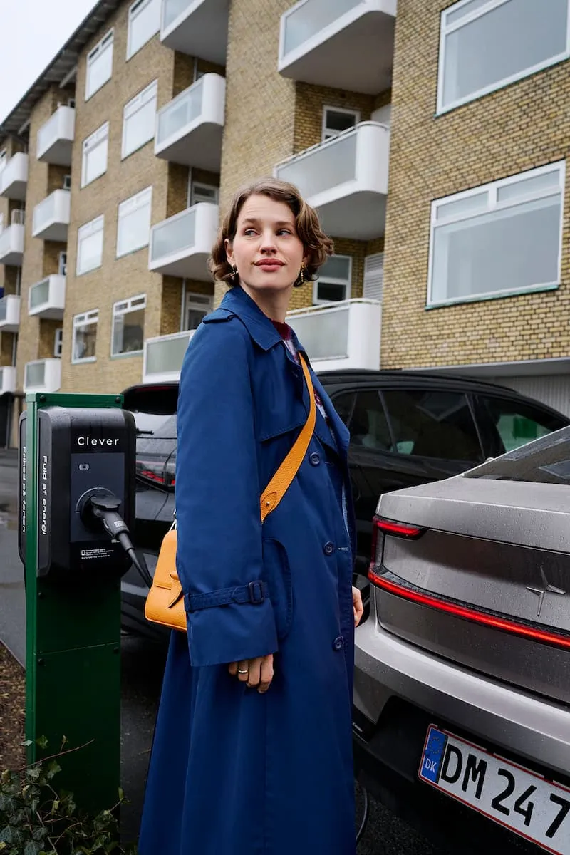 Kvinde oplader sin bil ved en boligforening på en ladeboks fra Clever