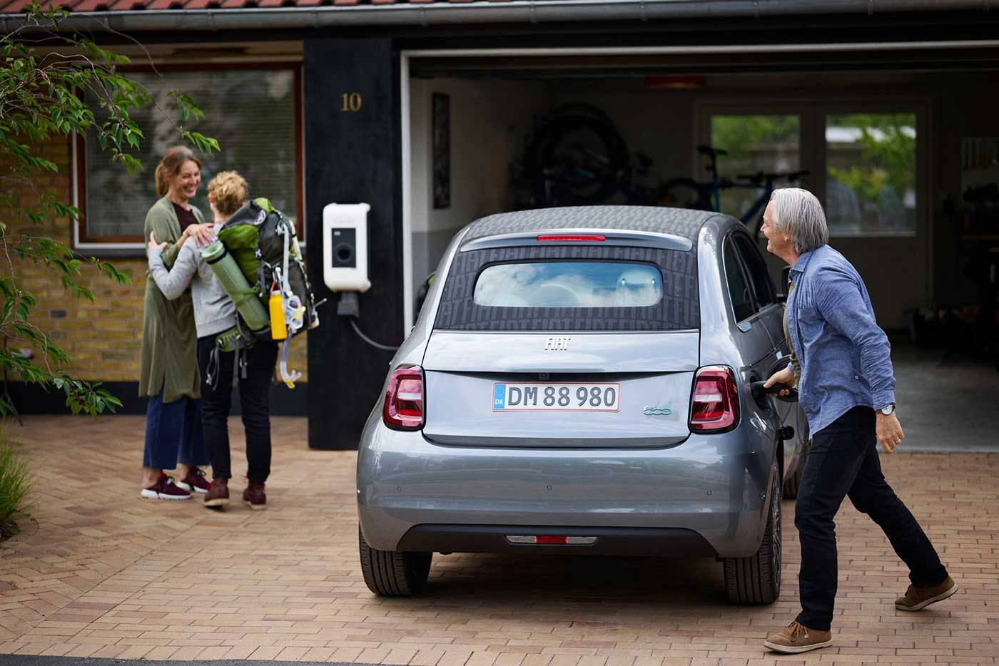 En familie står ved en Clever ladeboks i deres indkørsel