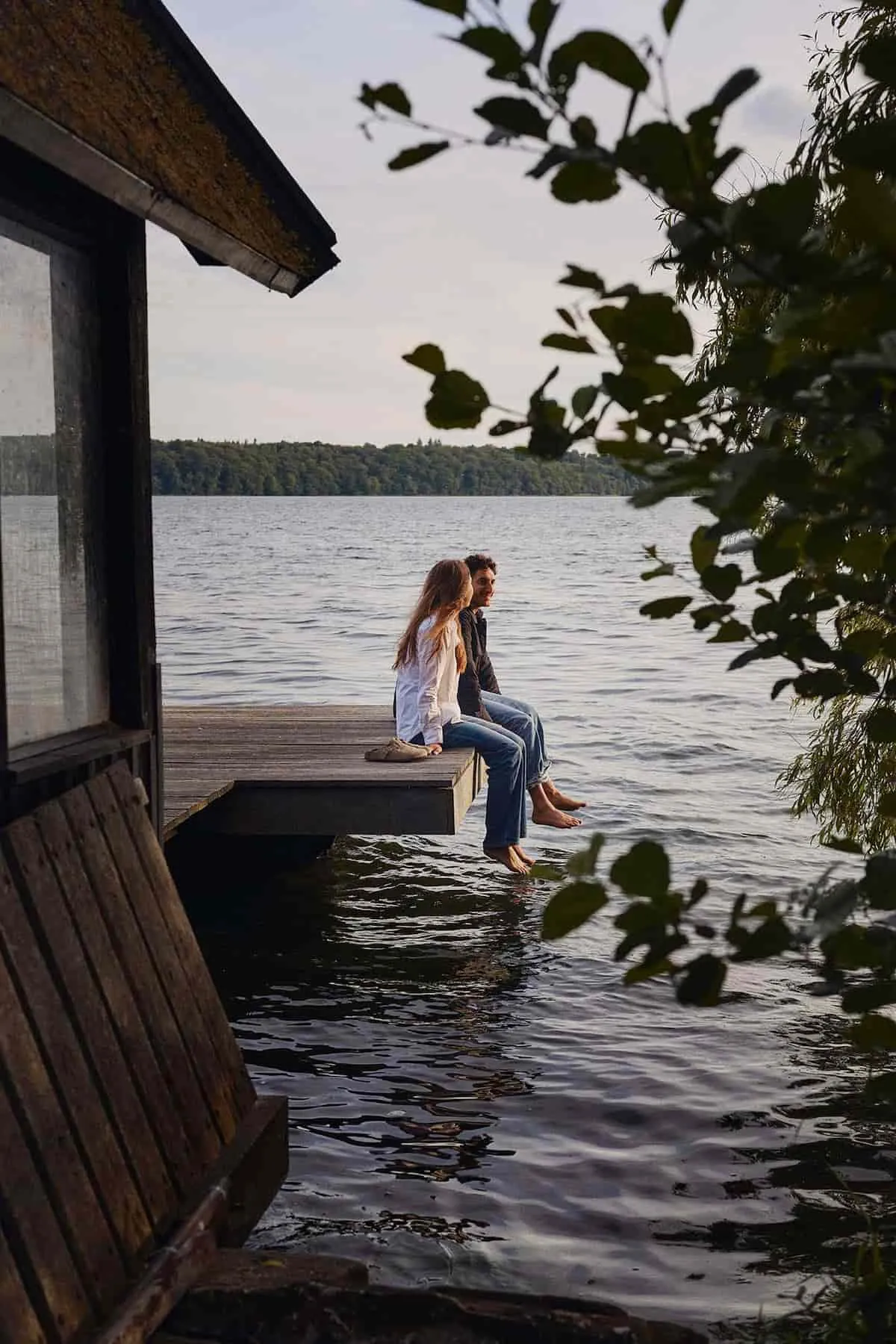 En mand og en kvinde sidder på en badebro og taler sammen