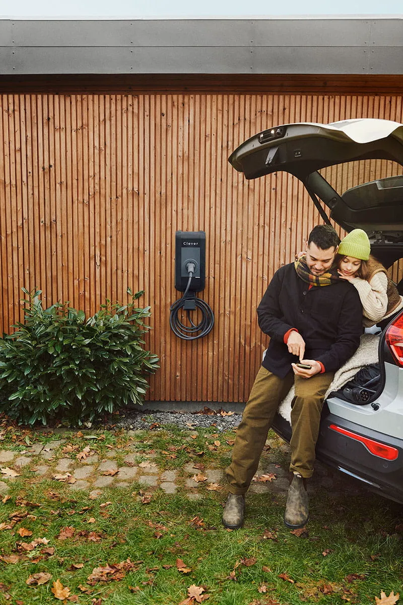 Familie er i bil ved et hus med Clever ladestander